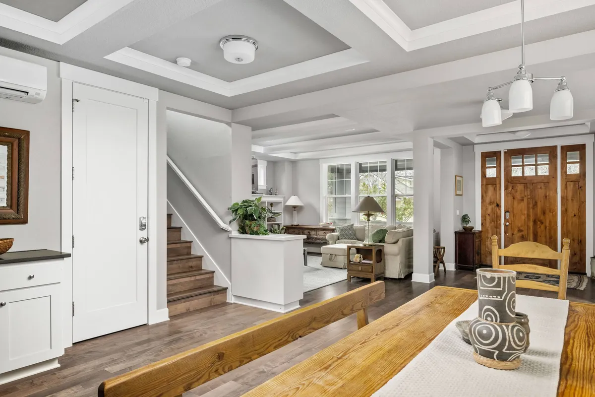 An inviting interior dining area featuring a spacious dining table, open living area, and decorative accents. The layout suggests a welcoming space for group gatherings, socializing, or unwinding after exploring the city.